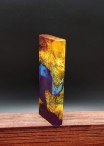 This image portrays Luminescent Cosmic Burl Dynavap Stash by Dovetail Woodwork.