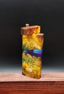 This image portrays Luminescent Cosmic Burl Dynavap Stash by Dovetail Woodwork.
