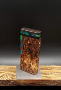 This image portrays Luminescent Cosmic Burl-Dynavap Stash Case by Dovetail Woodwork.