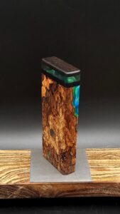 This image portrays Luminescent Cosmic Burl-Dynavap Stash Case by Dovetail Woodwork.