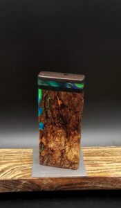 This image portrays Luminescent Cosmic Burl-Dynavap Stash Case by Dovetail Woodwork.