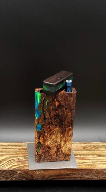 This image portrays Luminescent Cosmic Burl-Dynavap Stash Case by Dovetail Woodwork.